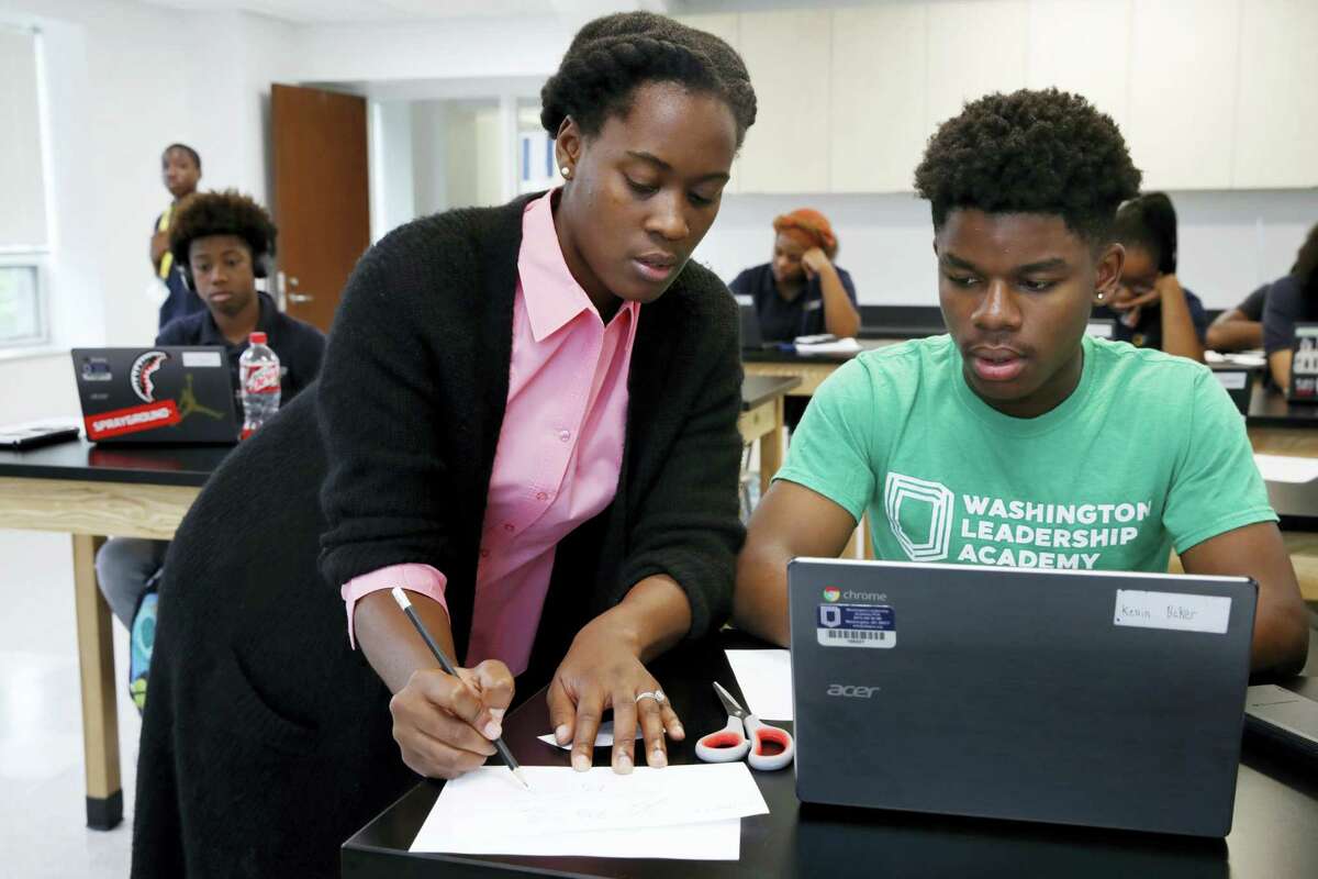 Britney Wray, a math teacher at Washington Leadership Academy, helps sophomore Kevin Baker, 15, with a math problem during class in Washington, Wednesday, Aug. 23, 2017. Students took diagnostic tests using special software. As they solved math problems on their laptops, the system diagnosed their proficiency levels in real time, part of “personalized learning.” This approach uses software, data and constant monitoring of student progress to adapt teaching to each child’s strengths, weaknesses, interests and goals and enable them to master topics at their own speed.