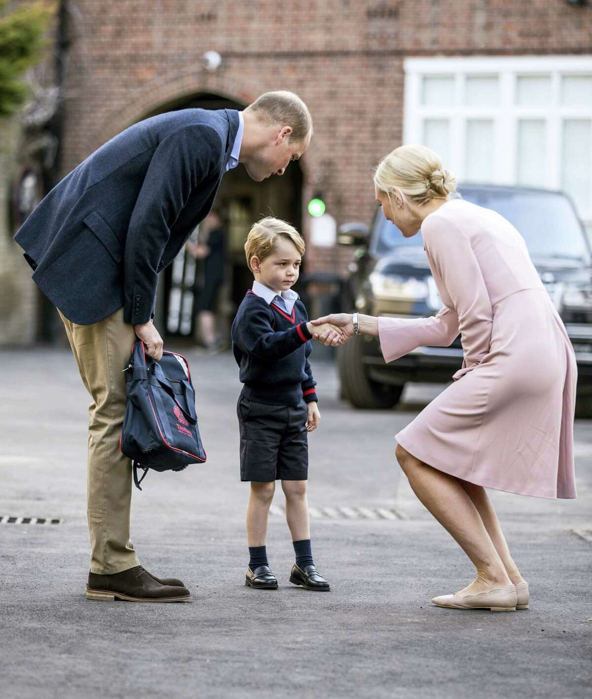 Britain's Prince William accompanies Prince George as he is greeted by Helen Haslem - the head of the lower school as he arrives for his first day of school at Thomas's school in Battersea, London, Thursday, Sept. 7, 2017. Prince William's pregnant wife Kate was too ill with morning sickness Thursday to take young Prince George to his first day of school.
