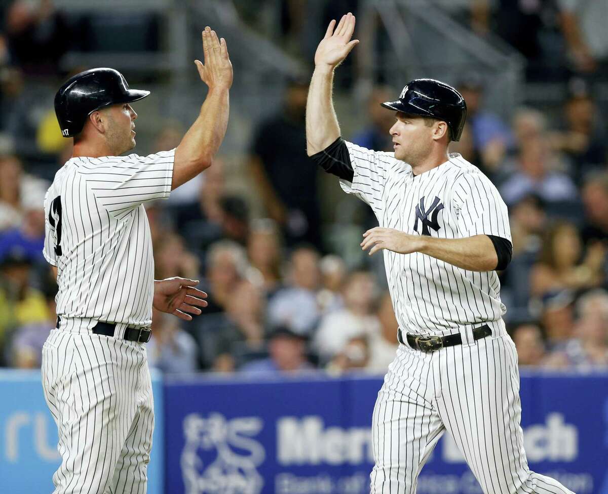 New York Yankees designated hitter Matt Holliday, left, greets Chase Headley after they scored on Todd Frazier’s two-run single during the fourth inning of a baseball game against the Detroit Tigers at Yankee Stadium in New York on July 31, 2017.