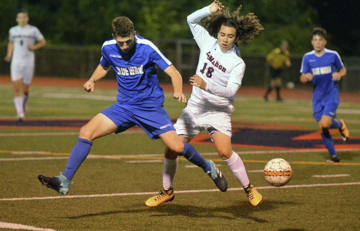 Darien's #2 Elia Vetter battles for the ball with Brien McMahon's #18 Christopher Ocampo during Boys soccer action at Brien McMahon High School on Tuesday.