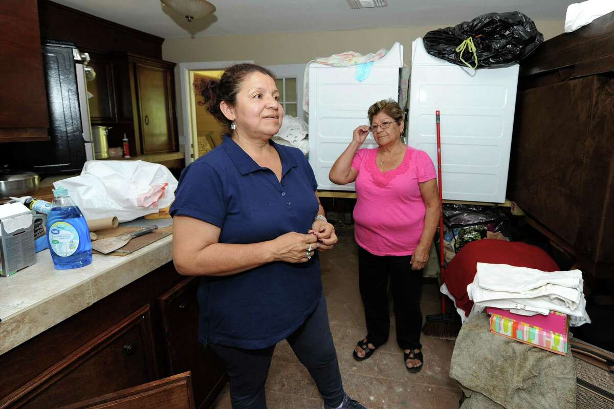Laura Rendon describes the damage her family's homes sustained the Tinsley Estates area near the Brazos River in Rosenberg, TX as her mother, Angelina Arguello looks over her shoulder on September 7, 2017.