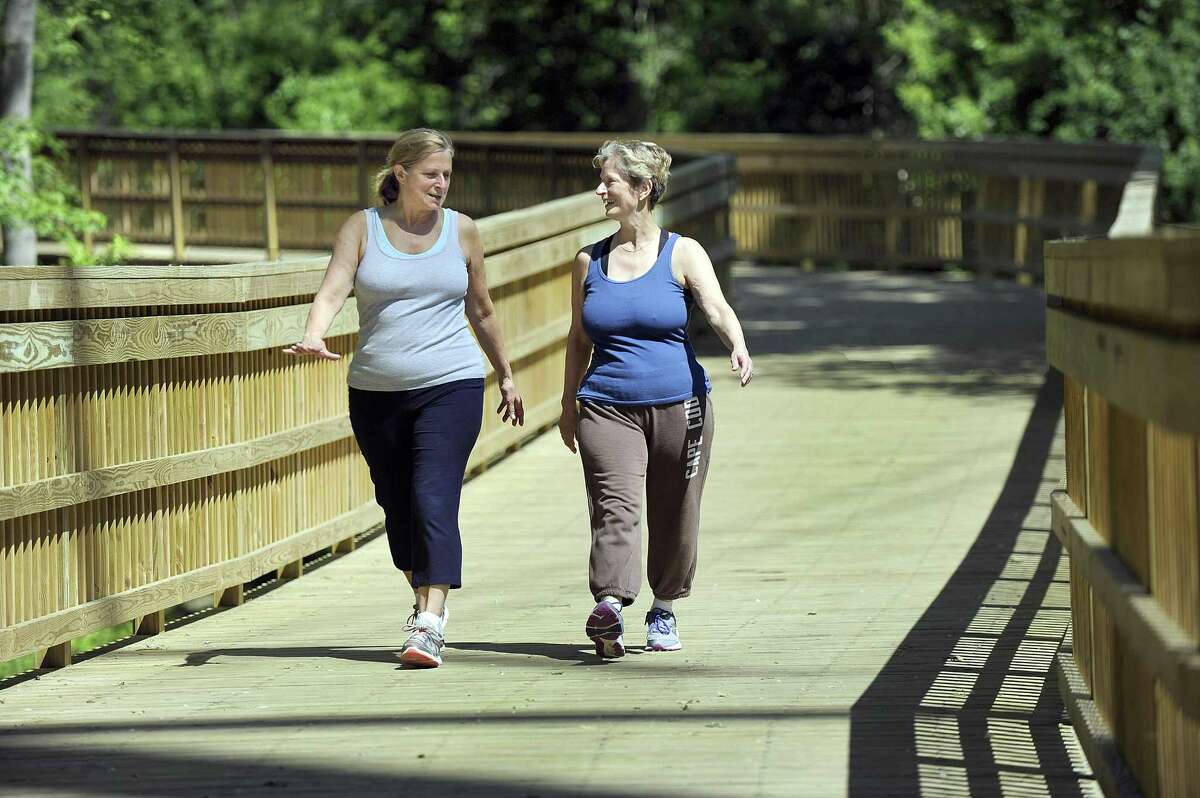 Anita Francisco, left, and her sister, Debbie Clark, go for a walk on the Still River Greenway in Brookfield in June.