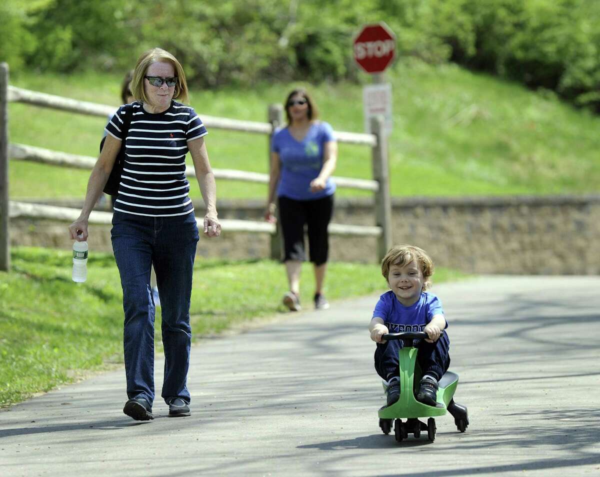 While others, including grandmother Karen Prancuk, left, walk, Timmy Prancuk, 3, of Brookfield, rides his scooter on the Still River Greenway Friday, April 28, 2017. The Greenway is a two mile hike and bike trail in Brookfield.