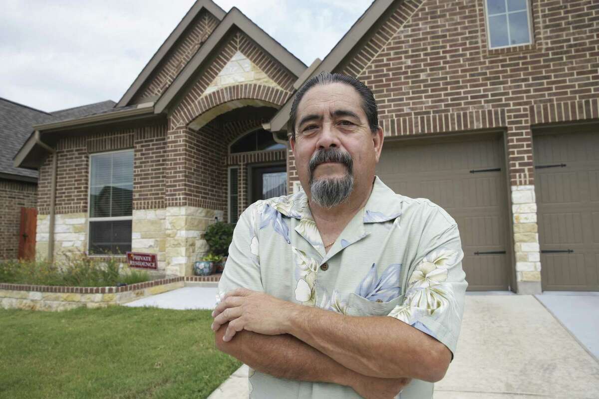 Air Force veteran Roy Ledesma stands in front of his home after he goes over information pertaining to refinancing in San Antonio on September 20, 2017.