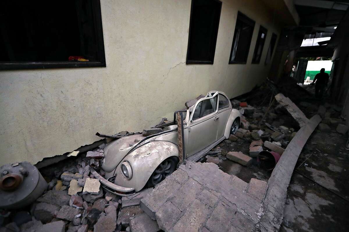 A car sits crushed from a building felled by a 7.1 earthquake, in Jojutla, Morelos state, Mexico, Wednesday, Sept. 20, 2017. Police, firefighters and ordinary Mexicans are digging frantically through the rubble of collapsed schools, homes and apartment buildings, looking for survivors of Mexico's deadliest earthquake in decades as the number of confirmed fatalities climbs. (AP Photo/Eduardo Verdugo)