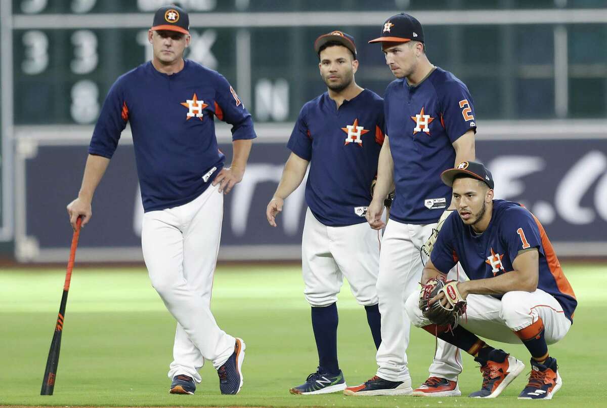 Astros players (from right) Carlos Correa, Alex Bregman and Jose Altuve and manager A.J. Hinch watch batting practice before a game against the Chicago White Sox at Minute Maid Park on Sept. 19, 2017, in Houston.