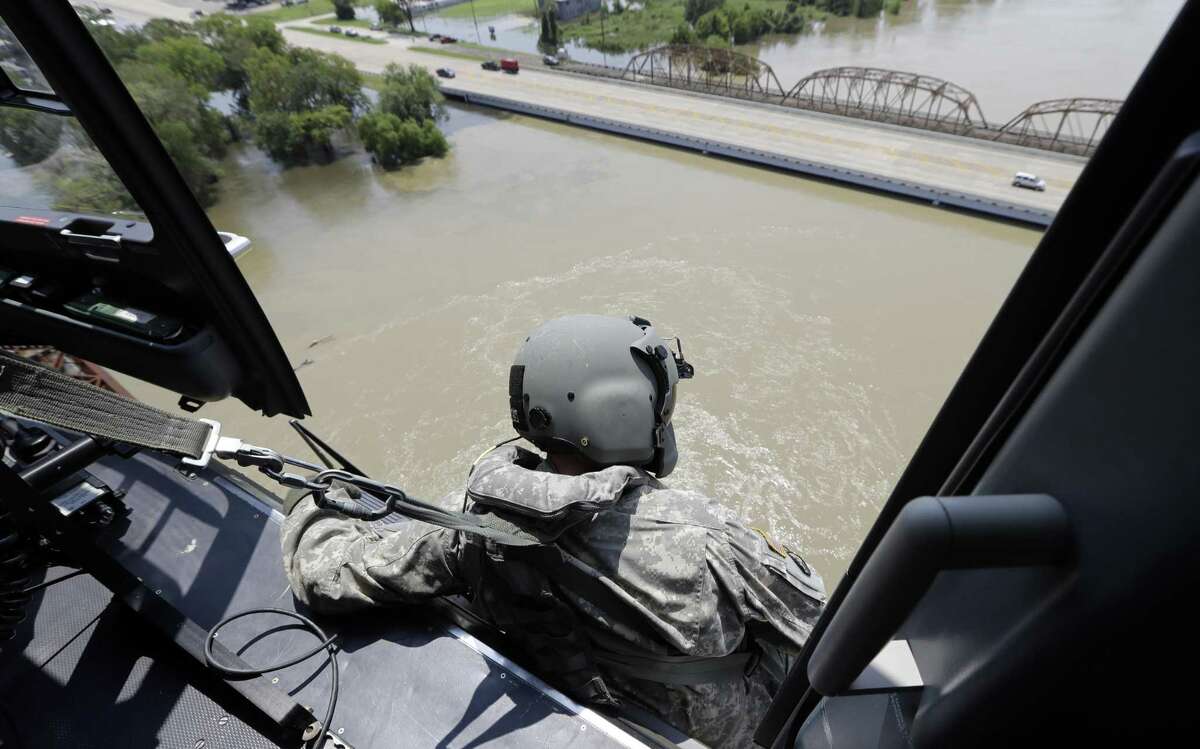 U.S. Army National Guard Staff Sgt. Drew Gleason looks for flood victims in the aftermath of Hurricane Harvey while flying over Liberty in this Sept. 1 photo. New hour-by-hour rainfall data collected by the National Weather Service shows a gauge in the city of Liberty northeast of Houston recorded 55 inches of rain during Harvey — a new record that surpasses even the 52 inches of rains from a tropical storm recorded in Hawaii in 1950.