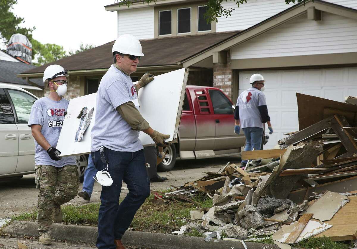 Sen. Ted Cruz (center) and a Team Rubicon Disaster Response member on Thursday help clean out a Harvey-damaged house in Friendswood. Cruz was part of congressional delegation, including House Speaker Paul Ryan, to assist Team Rubicon, a nonprofit that pairs military veterans with first responders, with relief efforts.