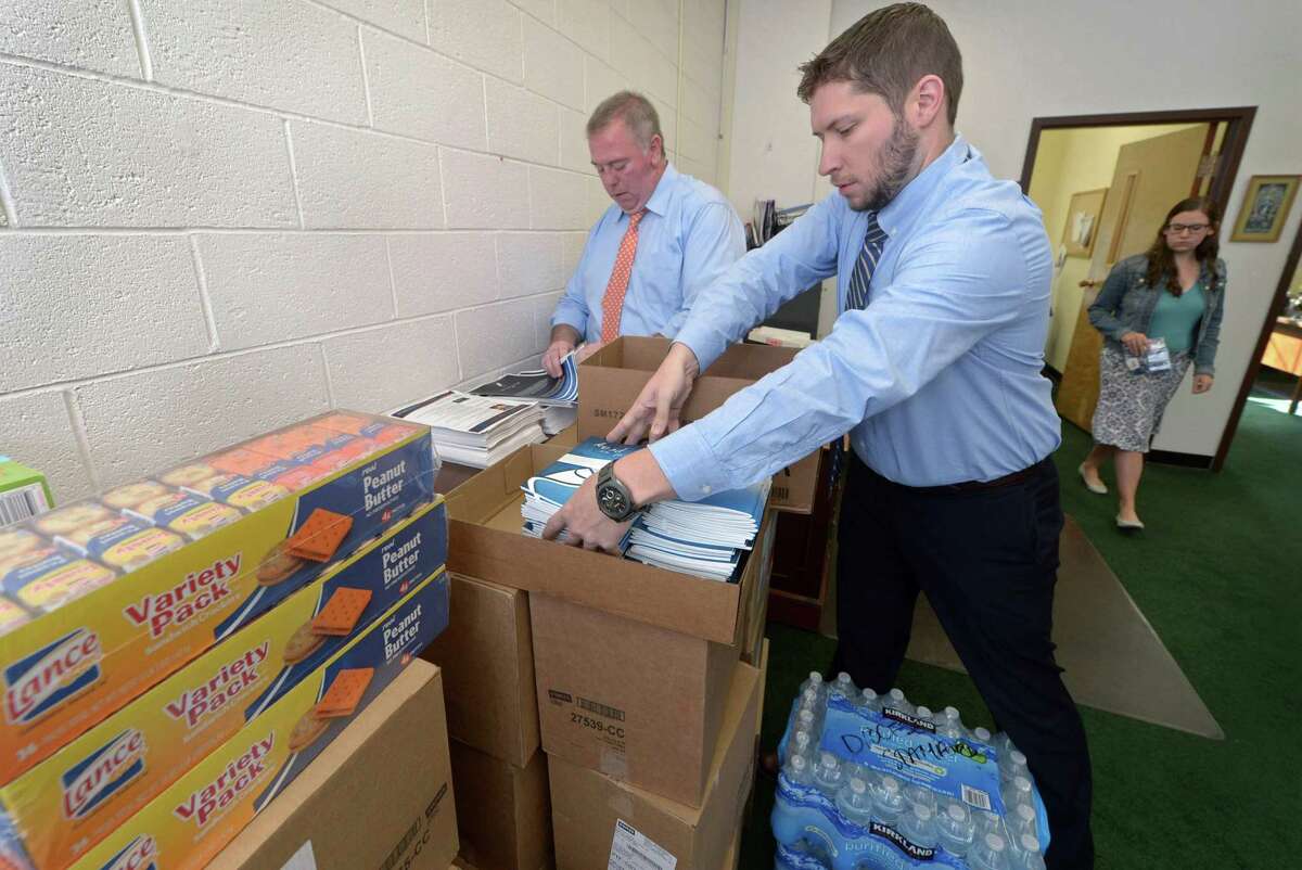 Leadership Institute Director Patrick Donovan and Youth and Young Adult Formation coordinator Evan Psencik pack rosaries and prayer books at The Catholic Center in Bridgeport on Thursday.