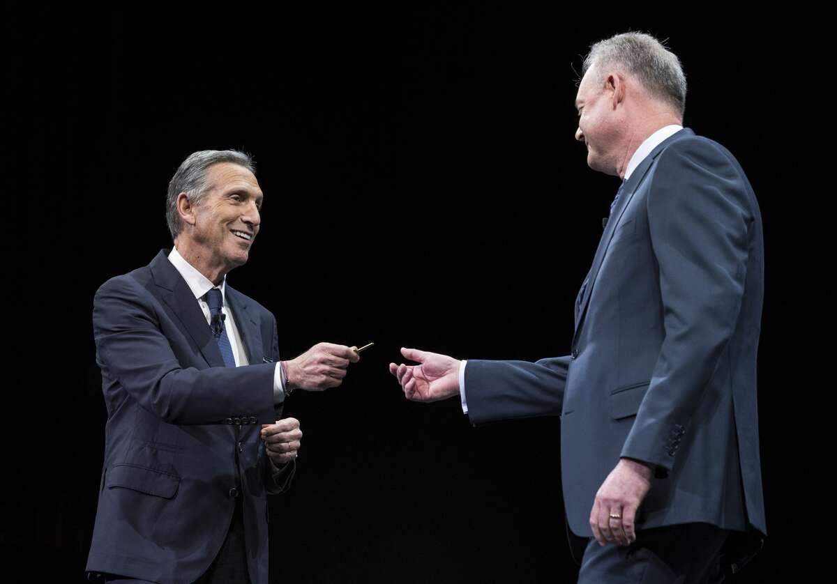 Howard Schultz (left) hands over the key to the original Starbucks store to President and Chief Operating Officer Kevin Johnson during last year's Starbucks annual meeting of shareholders on March 22, 2017 in Seattle.