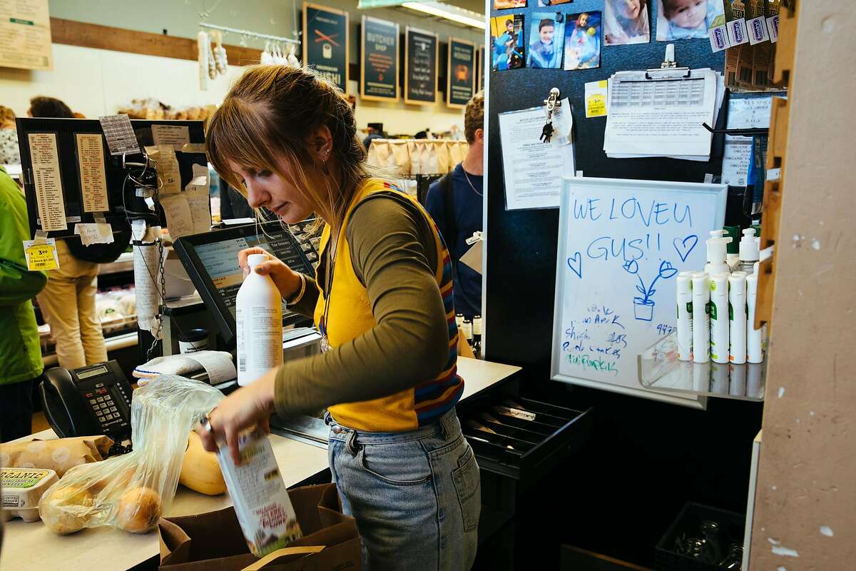 A sign reading "We Love you Guys" is seen at the cash register as Helena Joseph helps customers check out at the Haight Street Market in San Francisco, Calif. Friday, September 22, 2017.