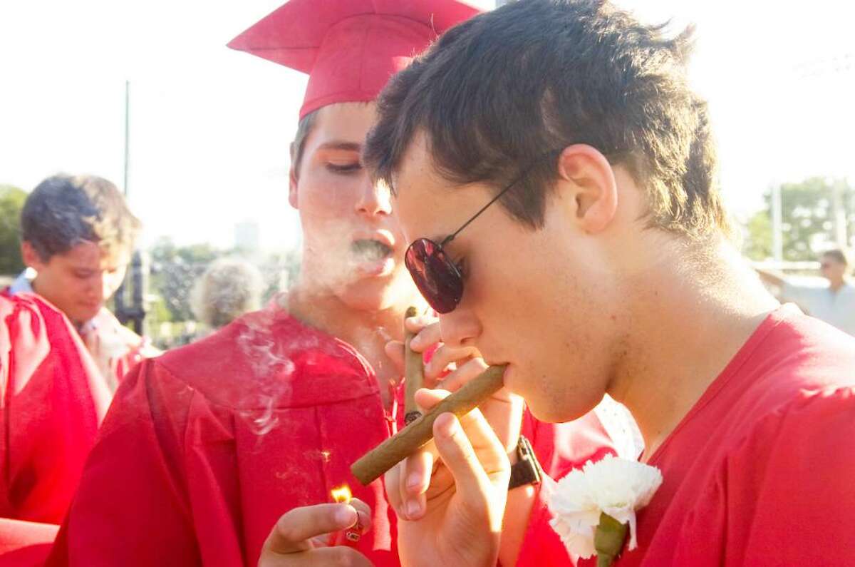 Kevin Campbell, right, gets a light from Oliver Citrin as the two indulge in celebratory cigars after the New Canaan High School Class of 2010 graduation ceremony Wednesday, June 23, 2010.