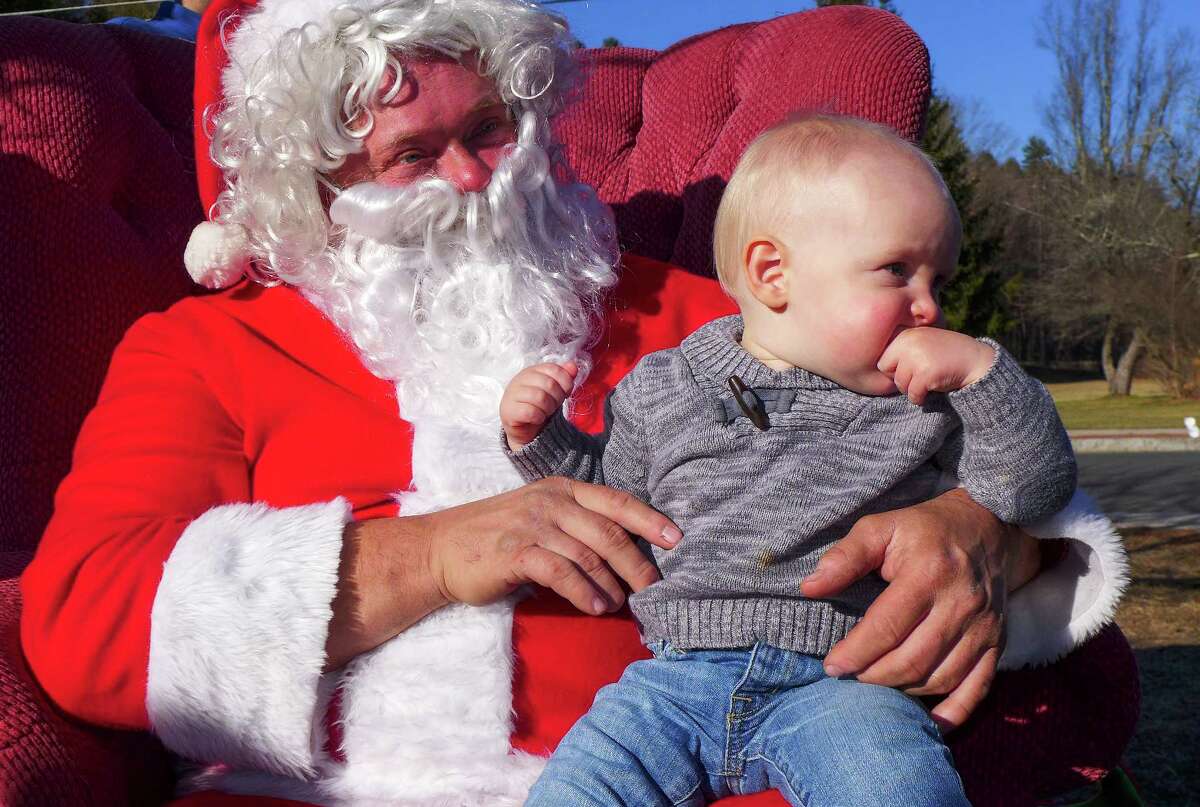 Photo by John Fitts Henry Pfeiffer, 13 months, of Newburyport, Mass ponders what to make of Santa at Christmas in Riverton on Saturday.