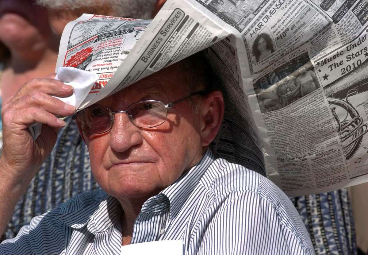 Because of the high temperatures, Millard Haynes, of Wallingford, tries to keep cool by keeping a newspaper on his head, during Foran High School's Graduation Exercises in Milford, Conn. on Wednesday June 23, 2010. Haynes was there to see his granddaughter Arlene Haynes graduate.