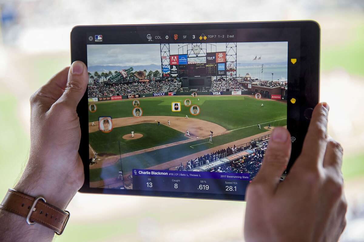 Chad Evans demonstrates the MLB At Batt app as Colorado Rockies Charlie Blackmon (highlighted) runs to second base at the top of the 7th inning at AT&T Park on Wednesday, Sept. 20, 2017, in San Francisco, Calif. Major League Baseball tech executives gave a preview of the new augmented reality portion of the MLB At Bat app, which uses Apple's new ARKit technology. This gives fans at games the ability to use iPhones and iPads to see how big a lead a runner has off first, highlight situations where a steal is likely, see real-time defensive positioning, understand the defensive range of the fielders, and see the gaps where hits would be likely.