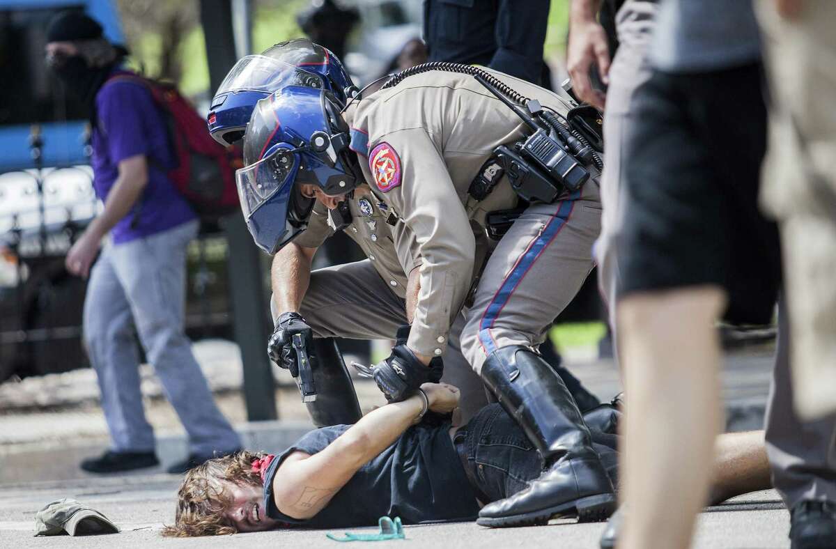 Protester Andrew Alemao is restrained on the pavement as a scuffle breaks out during a counter protest of people who are against white supremacy and fascism at the Capitol in Austin, Texas on September 23, 2017.