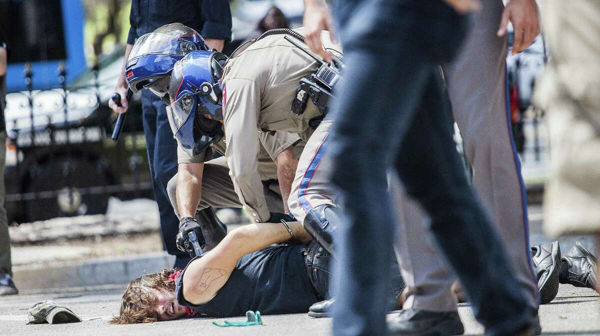 Protestor Andrew Alemao is restrained on the pavement after a scuffle broke out during a rally against Confederate monuments at the Capitol in Austin, Texas on September 23, 2017.