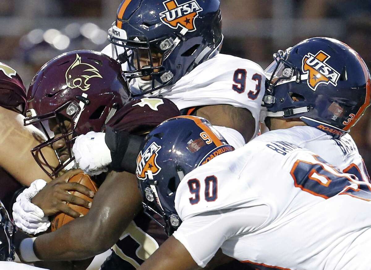 Texas State Bobcats quarterback Damian Williams (12) is gang tackled by UTSA Roadrunners defensive end Marcus Davenport (93), defensive end Eric Banks (90) and linebacker La’Kel Bass (31) during first half action on Sept. 23, 2017 at Bobcat Stadium in San Marcos.
