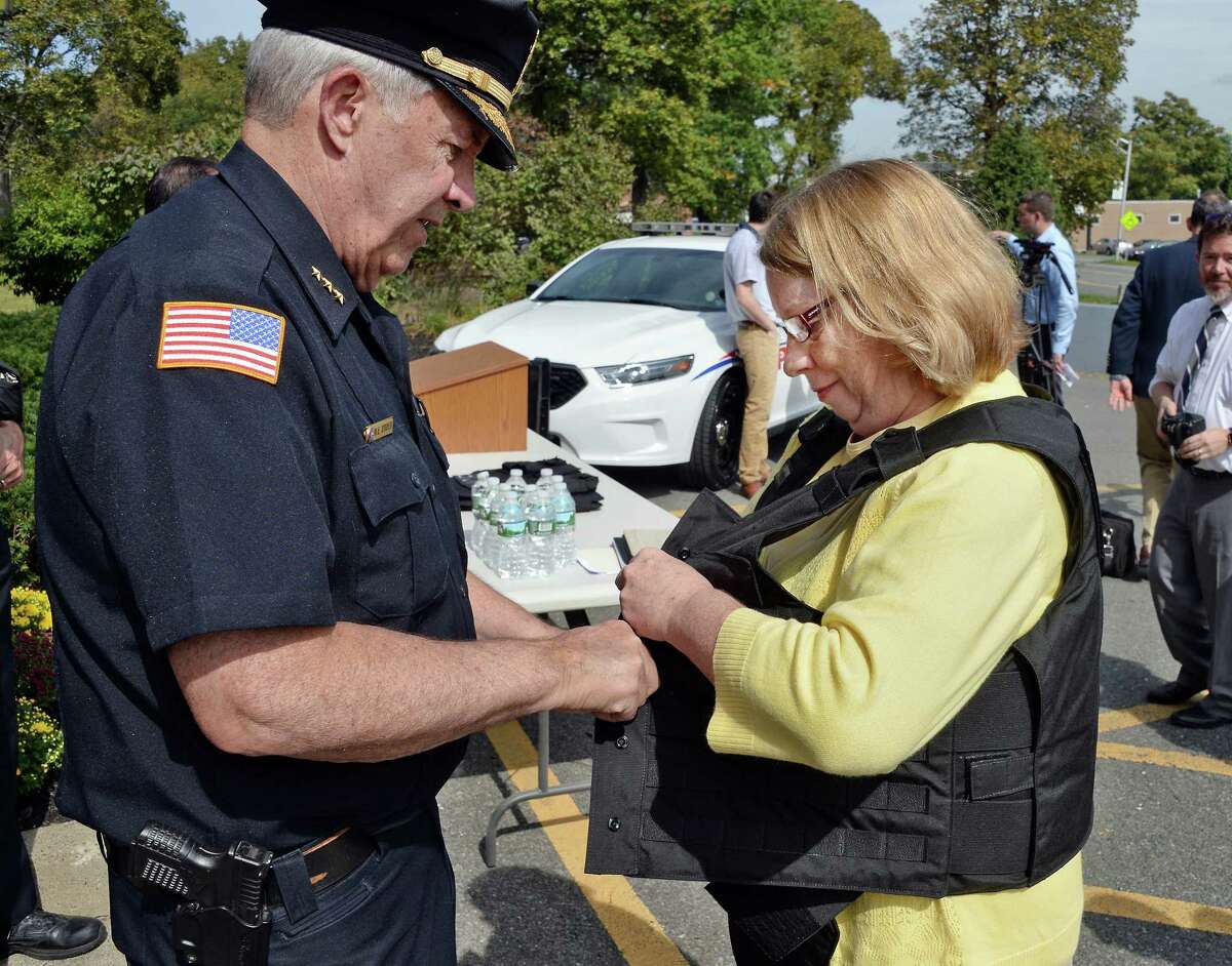 Menands Police Chief Michael O'Brien, left, has Mayor Megan Grenier try on a new bulletproof vests, part of a PERMA pilot program, during a news conference Thursday Sept. 21, 2017 in Menands, NY. (John Carl D'Annibale / Times Union)