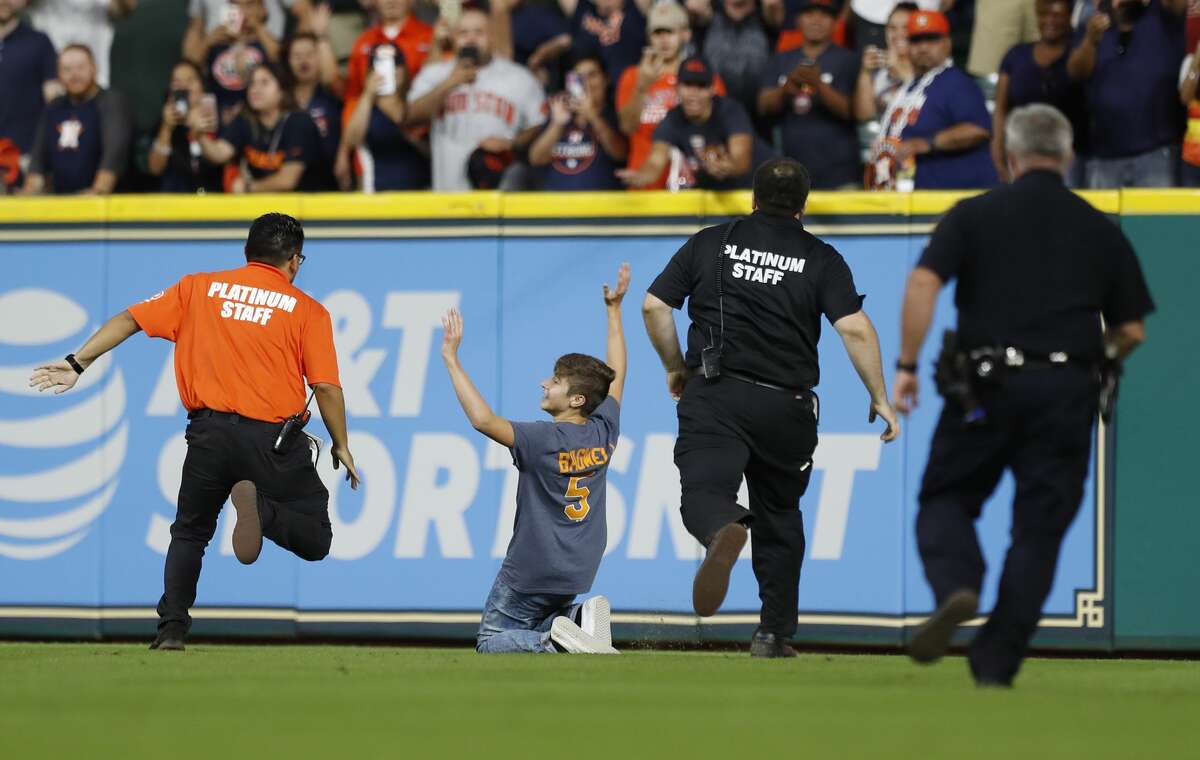 A kid stops as security and police gave chase during the seventh inning of an MLB baseball game at Minute Maid Park, Sunday, Sept. 24, 2017, in Houston. ( Karen Warren / Houston Chronicle )
