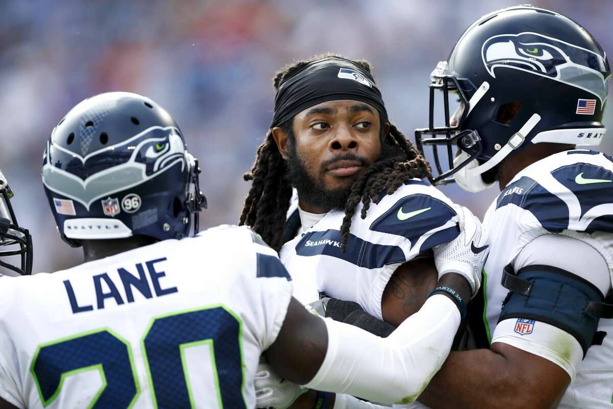 Cornerback Richard Sherman of the Seahawks is held back by his team after committing a foul against the Tennessee Titans at Nissan Stadium in Nashville last Sunday.