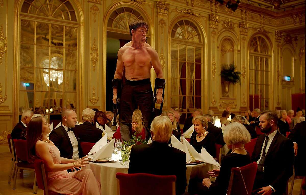 Terry Notary (standing) in Ruben ?–stlund's "The Square" (2017).