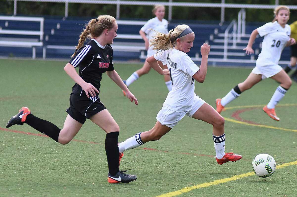 Wilton’s Piper Chase, right, pushes the ball up field in front of Fairfield Warde’s Lauren Tangney during the first half of Monday’s FCIAC girls soccer game at Kristine Lilly Field in Wilton. Warde won 1-0 on Tangney’s goal.