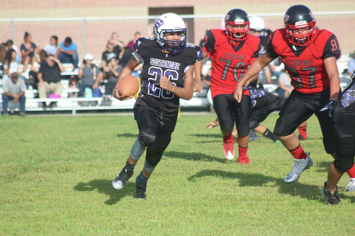 Southmore Intermediate's Ethan Torres looks for a running lane as a pair of Tigers give chase during first-half action Monday night. Torres finished with 80 yards rushing and 45 receiving in the 20-0 season-opening win.