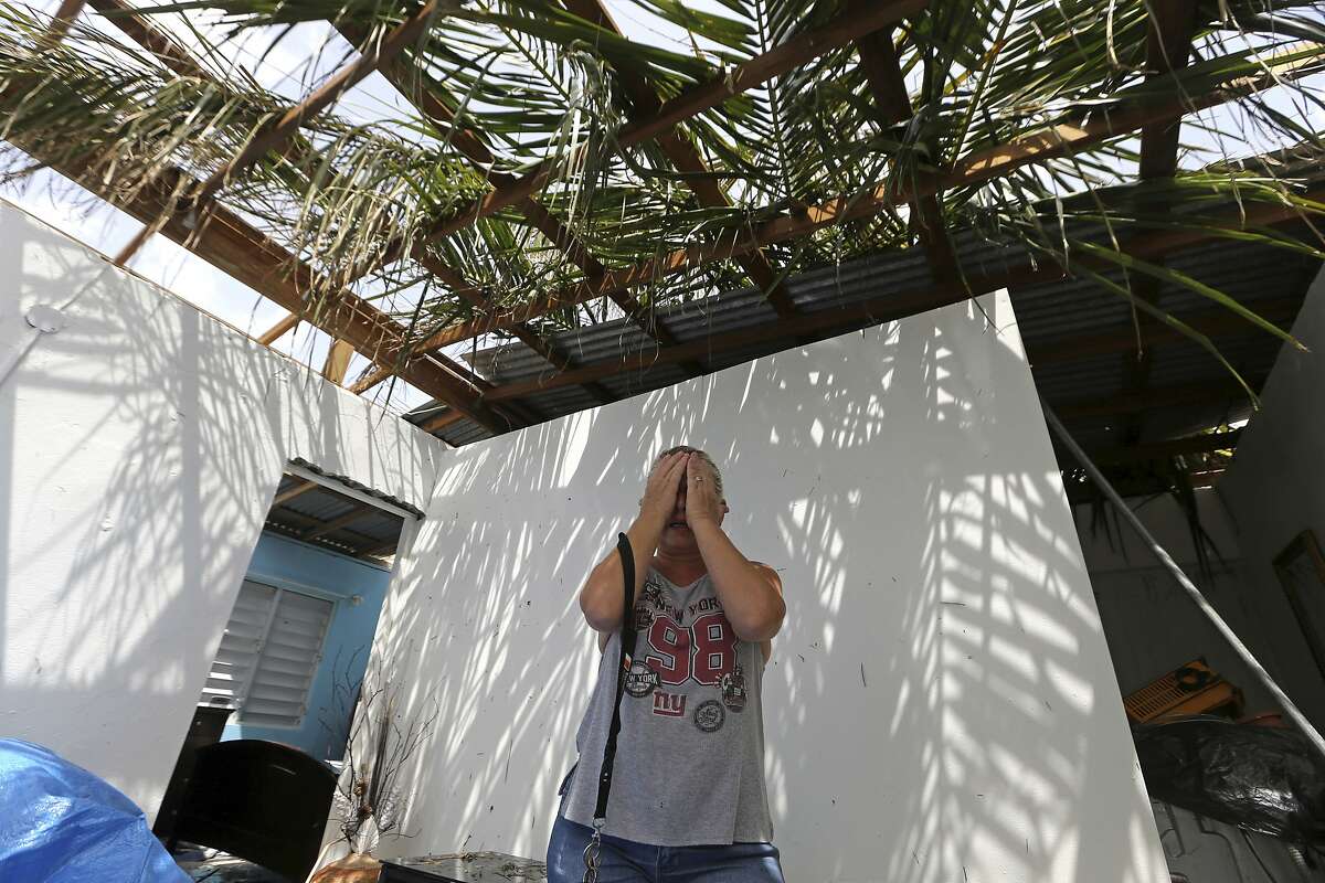 Nelida Trinidad talks about the destruction of her home in Montebello, Puerto Rico, in the aftermath of Hurricane Maria, Tuesday, Sept. 26, 2017. Five days after the Category 4 storm slammed into Puerto Rico, many of the more than 3.4 million U.S. citizens in the territory were still without adequate food, water and fuel. Flights off the island were infrequent, communications were spotty and roads were clogged with debris. Officials said electrical power may not be fully restored for more than a month. (AP Photo/Gerald Herbert)