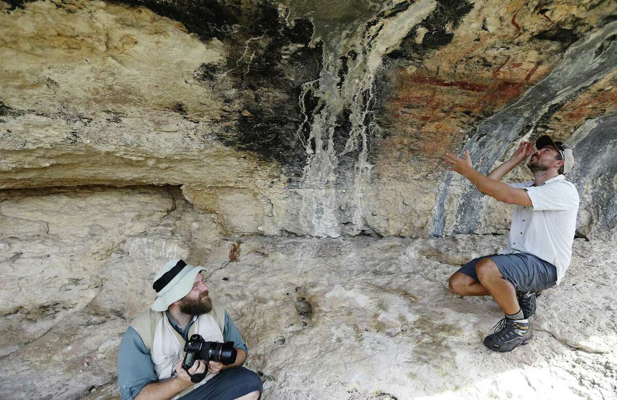 Archaeologists Jerod Roberts (left) and Charles Koenig study a cave painting located on a private ranch in Val Verde County. The two archaeologists are with the Shumla Archaeological Research & Education Center that are cataloging and digitizing ancient cave paintings at 300 sites around Comstock, Texas.
