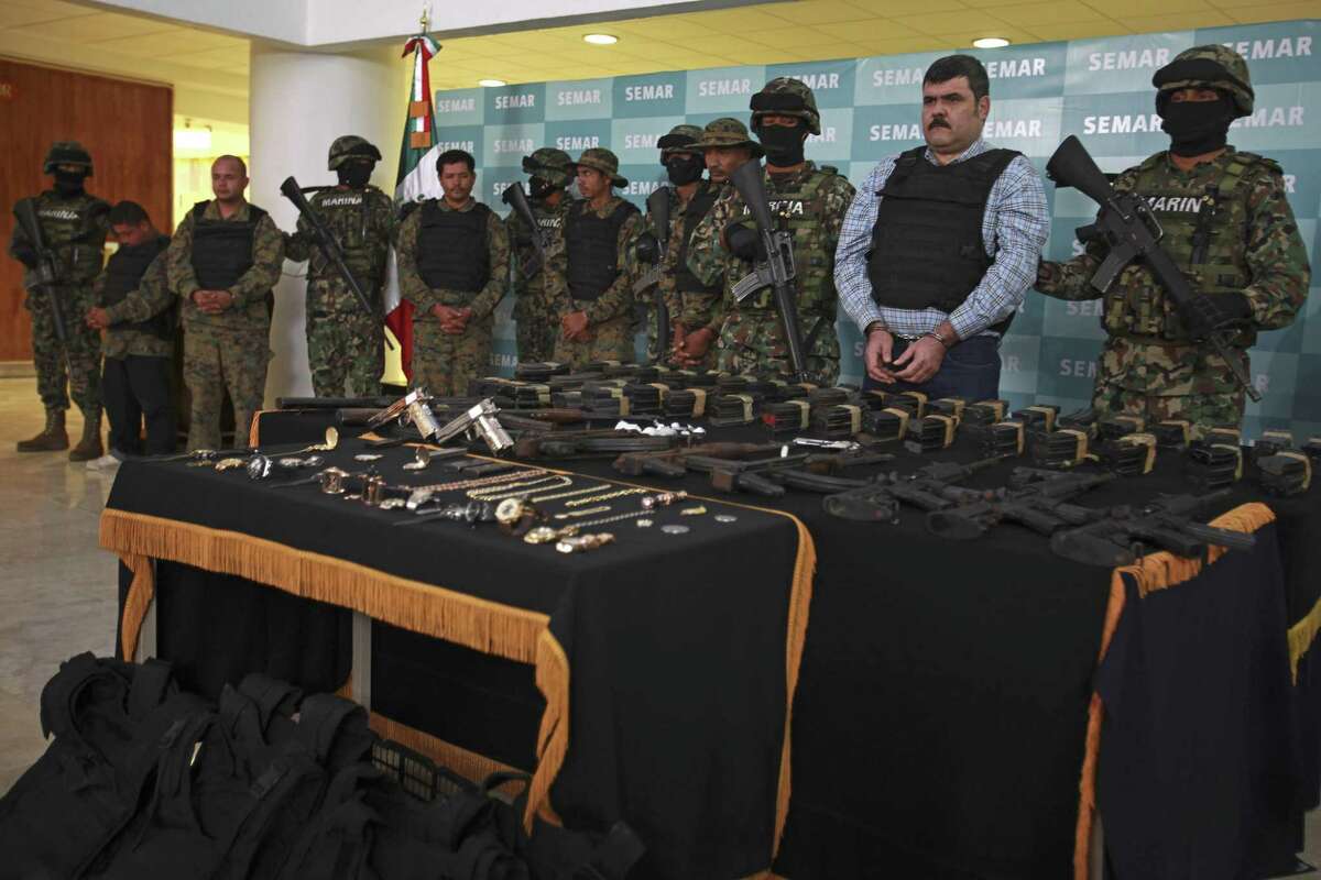 Mexican Navy marines flank a top leader of the Gulf drug cartel, Jorge Eduardo Costilla Sanchez, known as “El Coss,” second from right, as he is presented to the media along with other men dressed in military fatigues believed to be Costilla's bodyguards, at the Mexican Navy's Center for Advanced Naval Studies in Mexico City in September 2012. Costilla has pleaded guilty to conspiracy drug charges and assault, federal authorities said Tuesday.