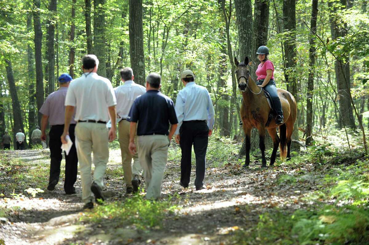 A horse and rider wait for a group from the state Siting Council, Ameresco and some town officials to pass during a walking tour of the area where there is a proposal to build solar panels on Candlewood Mountain in New Milford, Tuesday, Sept. 26, 2017. On Thursday, Dec. 21, 2017, the Connecticut Siting Council has approved the petition to allow Ameresco Inc. to build a solar farm on Candlewood Mountain.