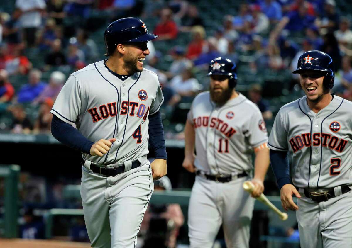 Houston Astros center fielder George Springer (4) and Alex Bregman (2) celebrate scoring on a Carlos Correa double in the first inning of a baseball game against the Texas Rangers on Tuesday, Sept. 26, 2017, in Arlington, Texas. (AP Photo/Tony Gutierrez)