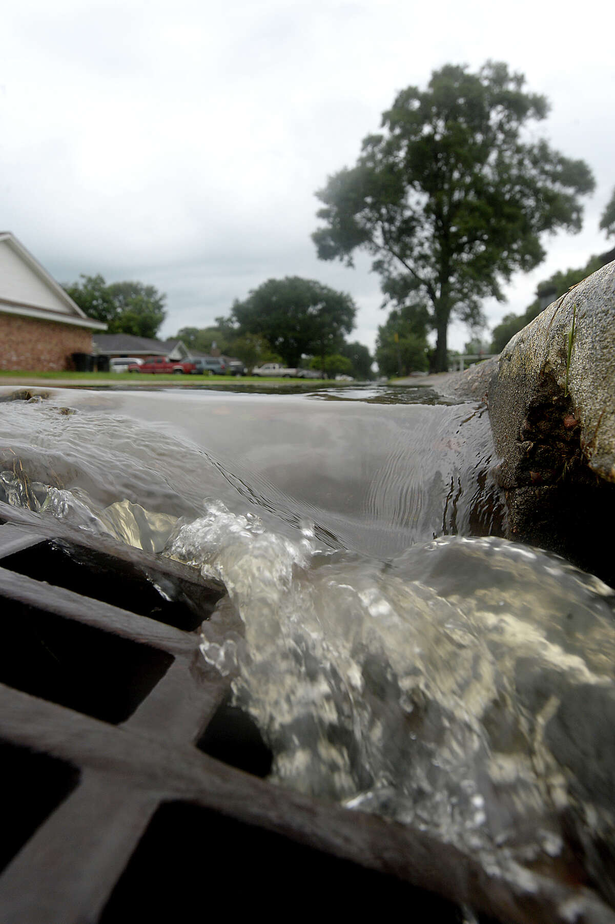 Water pours into a storm drain on 31st Street in Nederland as spotty bursts of rain move through the area Saturday, briefly accumulating on streets near Nederland Avenue, which is prone to flooding in heavy rainfalls. Heavier rains and wind from the outer bands of Hurricane Harvey, which was downgraded to a tropical storm, are expected to impact the Southeast Texas region within the coming days, increasing the risk for severe flooding. Photo taken Saturday, August 26, 2017 Kim Brent/The Enterprise