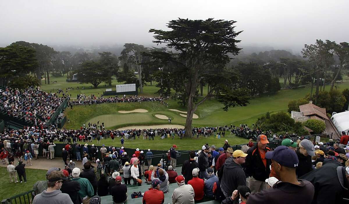 Fan watch a group on the 18th green during a practice round for the U.S. Open Championship golf tournament Wednesday, June 13, 2012, at The Olympic Club in San Francisco. (AP Photo/Charlie Riedel)