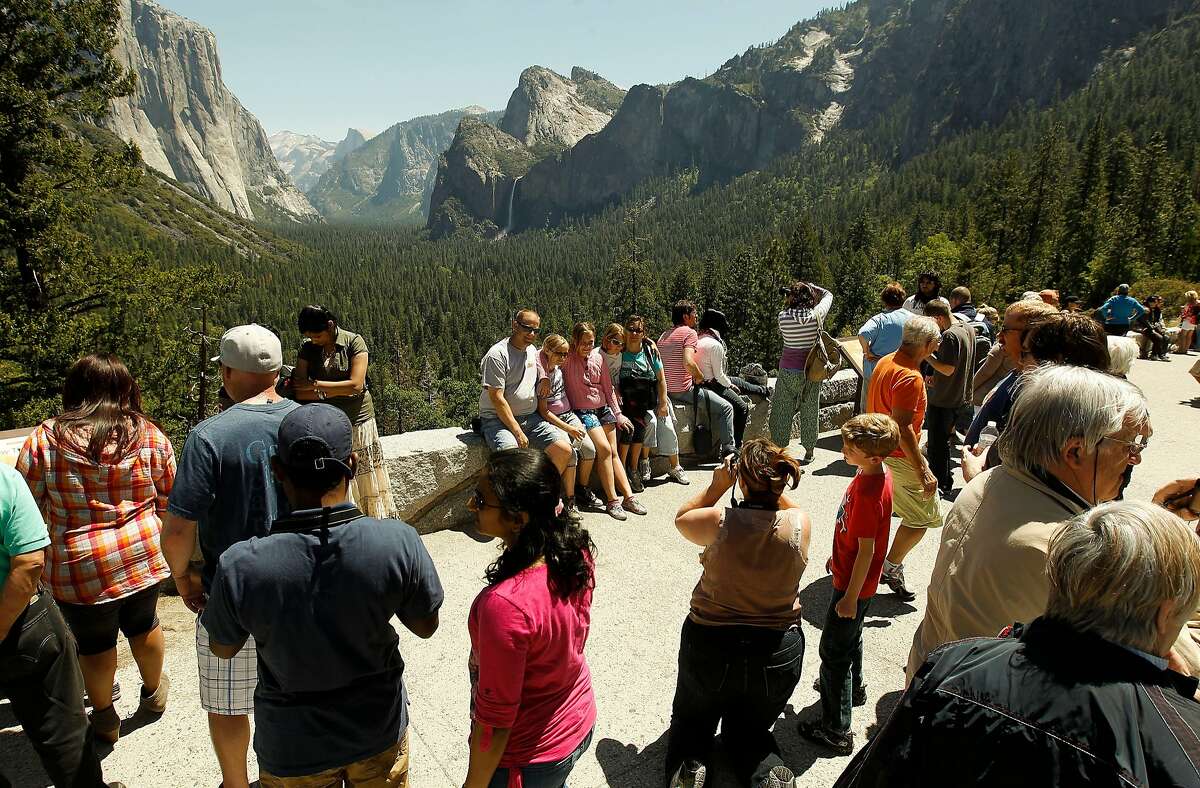 Park visitors gather at Tunnel View observation point, at Yosemite National Park, on Saturday May 12, 2012. Visitors to California national parks may notice more trash on trails, longer lines at service booths and fewer rangers this summer as the pinch of the federal government's budget problems grow increasingly difficult to overlook.
