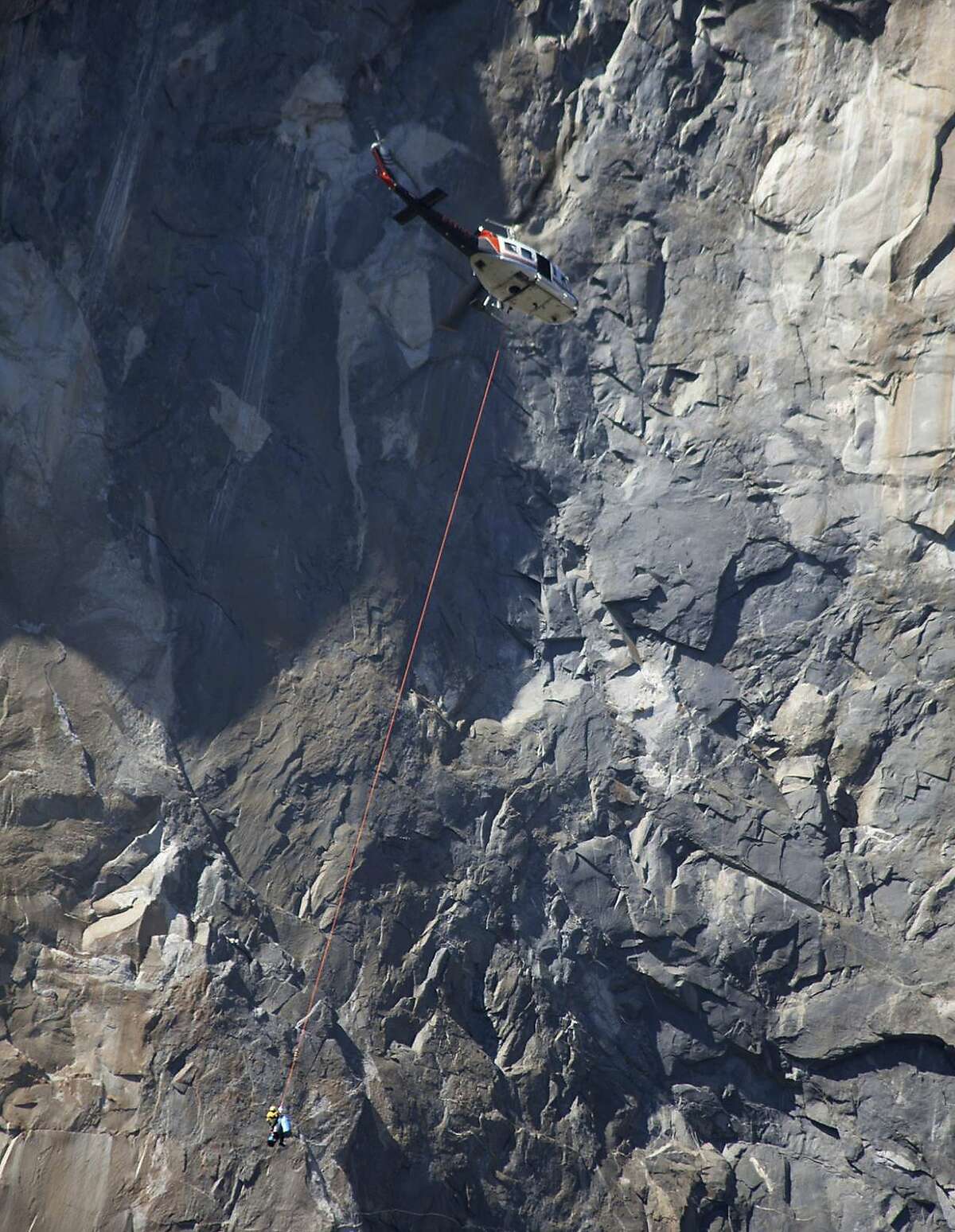 In this Wednesday Sept. 27, 2017, photo provided by Dakota Snider, photographer and Yosemite resident, a helicopter makes a rescue off El Capitan after a major rock fall in Yosemite National Park, Calif. All areas in California's Yosemite Valley are open Thursday, a day after the fatal rock fall. (Dakota Snider via AP)