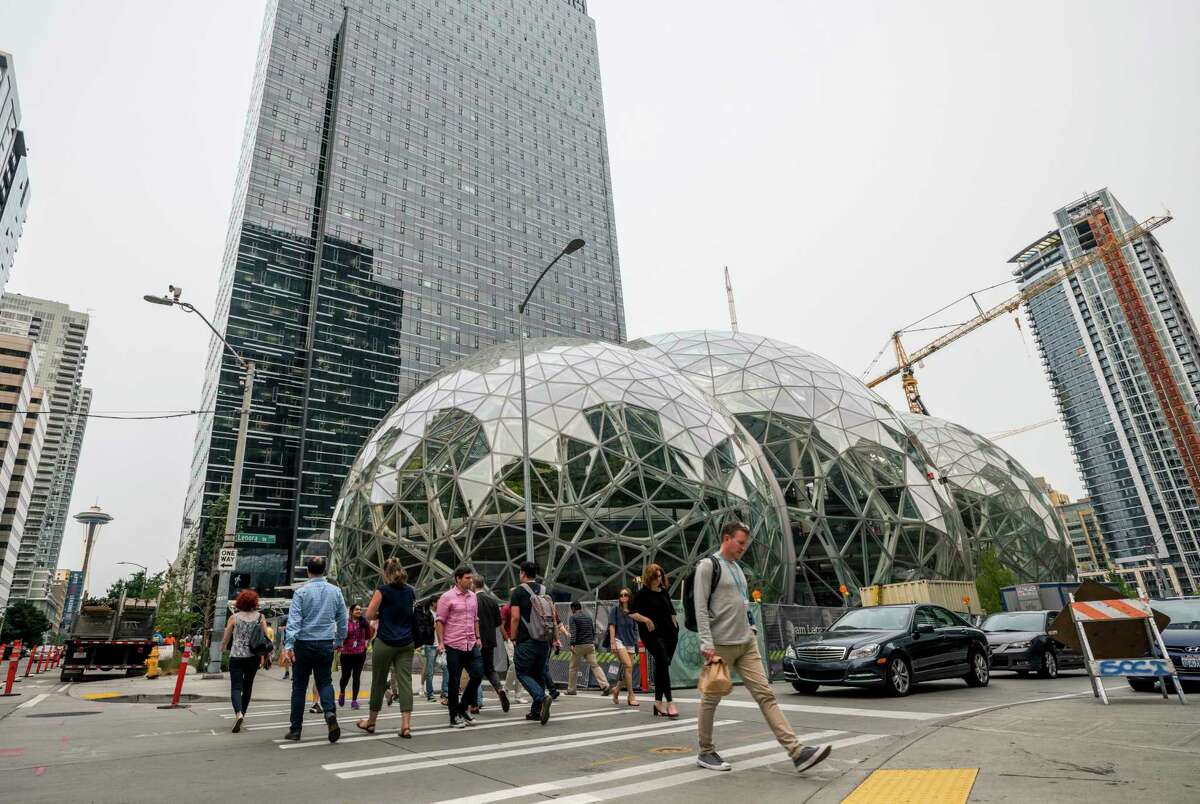 Pedestrians walk past a recently built trio of geodesic domes that are part of the Seattle headquarters for Amazon, Sept. 7, 2017. The online retail giant said it was searching for a second headquarters in North America in 2017, a huge new development that would cost as much as $5 billion to build and run, and house as many as 50,000 employees. (Stuart Isett/The New York Times)