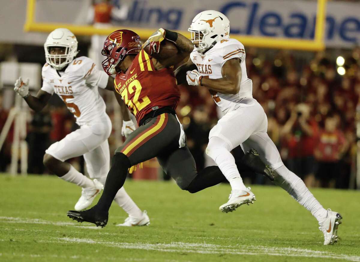 AMES, IA - SEPTEMBER 28: Running back David Montgomery #32 of the Iowa State Cyclones is tackled by defensive back DeShon Elliott #4, and defensive back Holton Hill #5 of the Texas Longhorns as he rushed for yards in the first half of play at Jack Trice Stadium on September 28, 2017 in Ames, Iowa. (Photo by David Purdy/Getty Images)