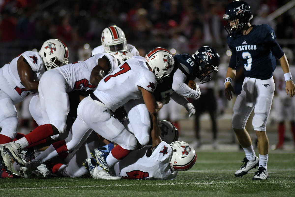 Kingwood senior quarterback Matt Slayton (3) watches as Mustang senior tailback Sebastian Garza (20) gets stopped by a swarm of Atascocita defenders, led by Eagle senior linebacker Cory Edwards (7) during the first quarter of their district opener at Turner Stadium in Humble on Sept. 29, 2017. (Photo by Jerry Baker/Freelance)