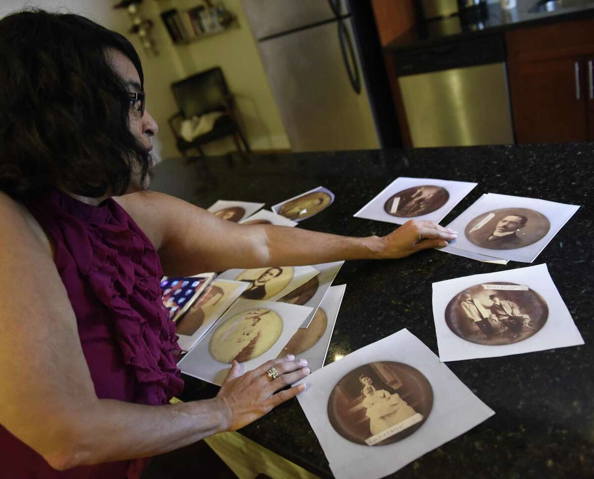 Teresa Vega shows tintype photographs of her distant ancestors at an apartment in the Inwood neighborhood of New York, N.Y. Tuesday, Sept. 26, 2017. Vega researched her family members, descended from slaves, who farmed in an area around Round Hill Road in Greenwich referred to as Hangroot.