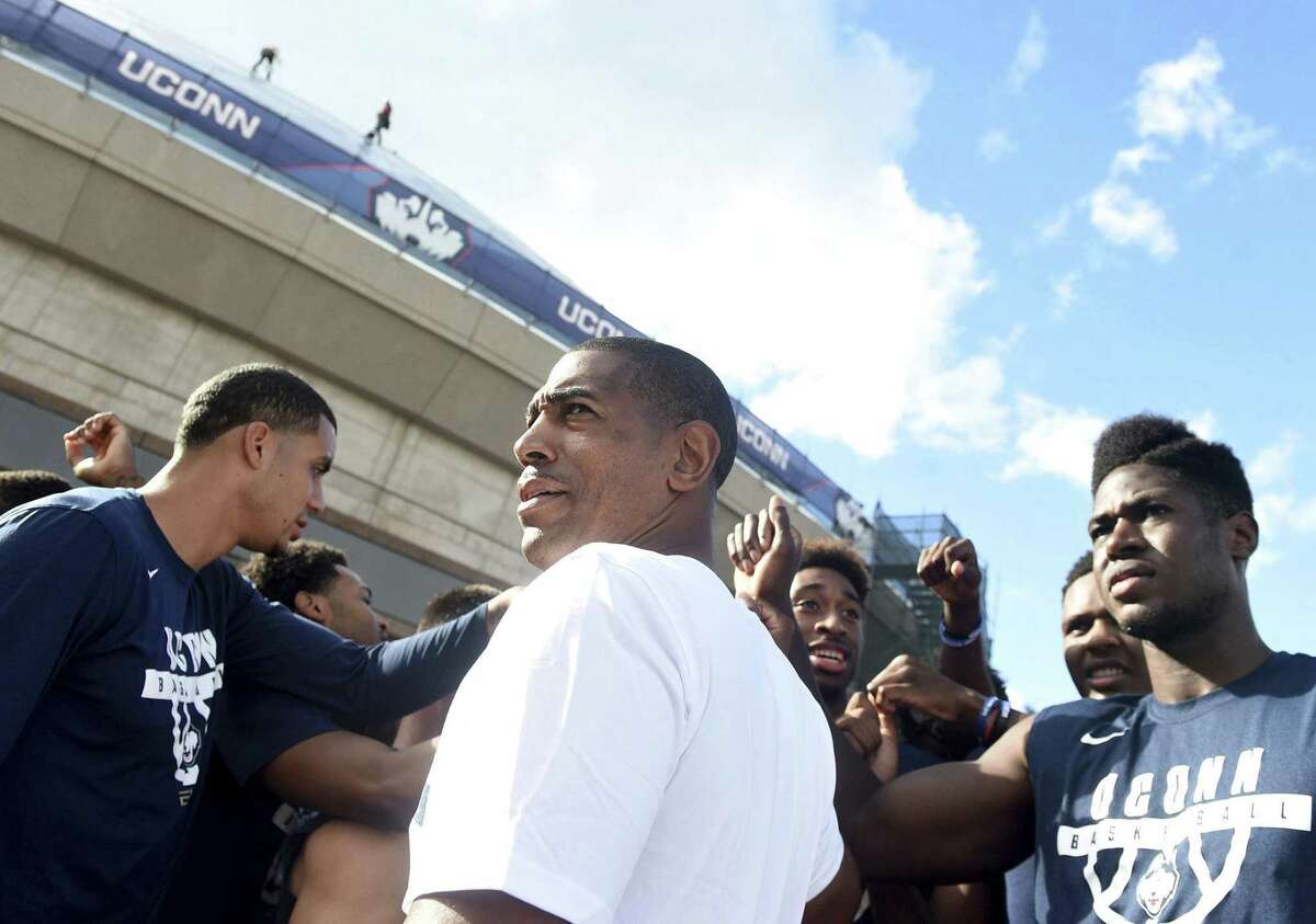 UConn coach Kevin Ollie, center, looks on during the annual Husky Run on Wednesday. The Huskies held their first practice on Saturday.