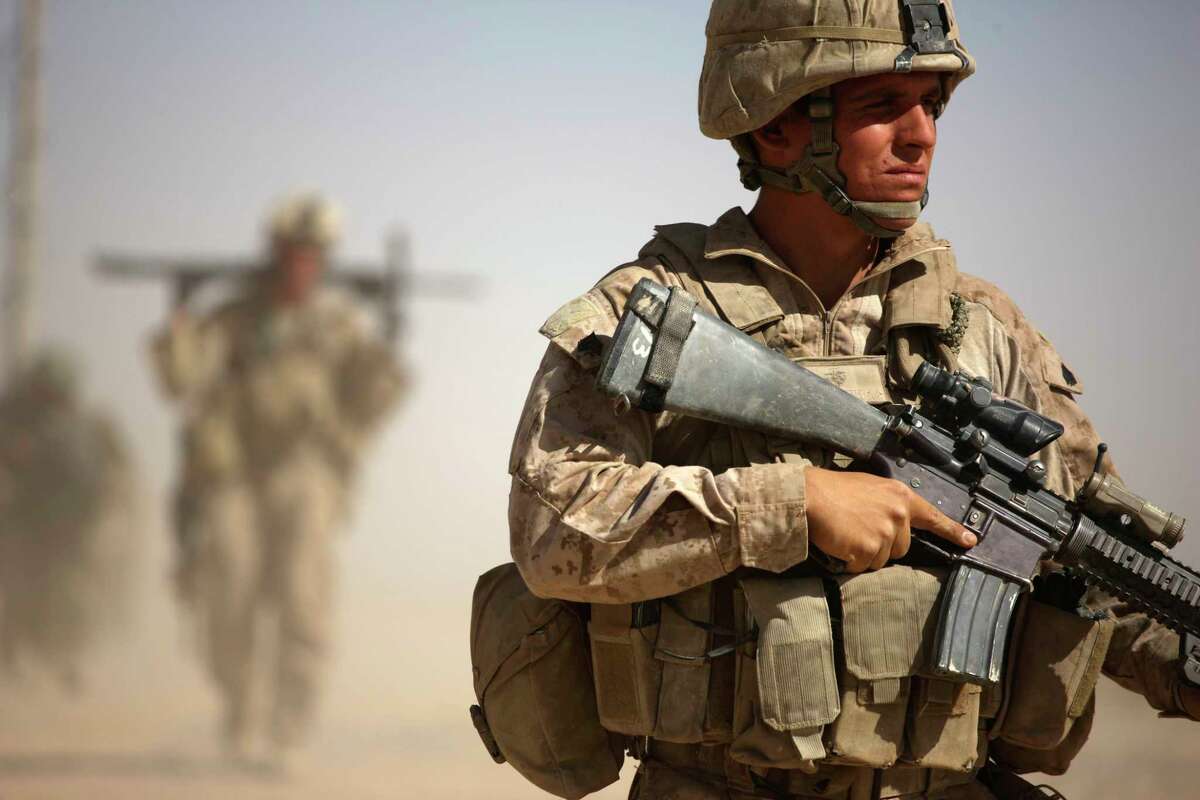 A U.S. Marine, right, with Bravo Company, 1st Battalion 5th Marines walks in a joint patrol with Afghan National Army soldiers, in Nawa district, Helmand province, southern Afghanistan, Saturday, Oct. 3, 2009. (AP Photo/Brennan Linsley)