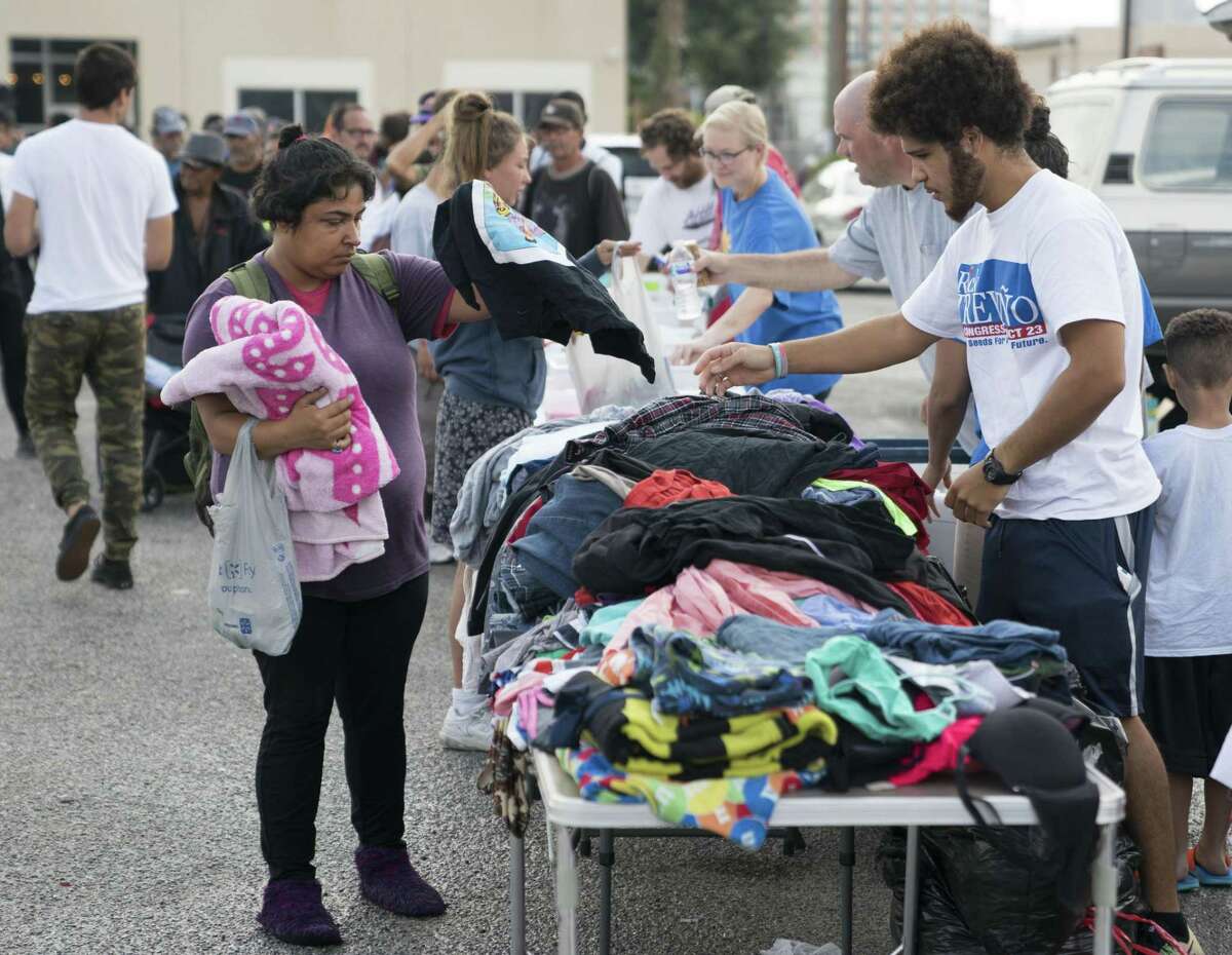 Sean Omar Rivera, right, helps Veronica Vigil select clothing donated to homeless citizens by South Texas Atheists for Reason, Sunday, Sept. 24, 2017, in downtown San Antonio. (Darren Abate/For the San Antonio Express-News)