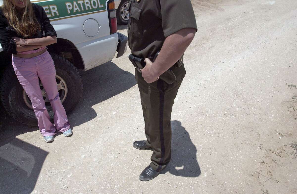 A 19-year-old woman from Mexico is questioned by the U.S. Border Patrol near Falfurrias after walking for two days in the brush. Her father, 42, was the latest rescue statistic by the patrol. He was given over to an ambulance because he was dehydrated. They each paid $1,500 to get from the border to Houston. Jesse Bogan, April 16, 2006.