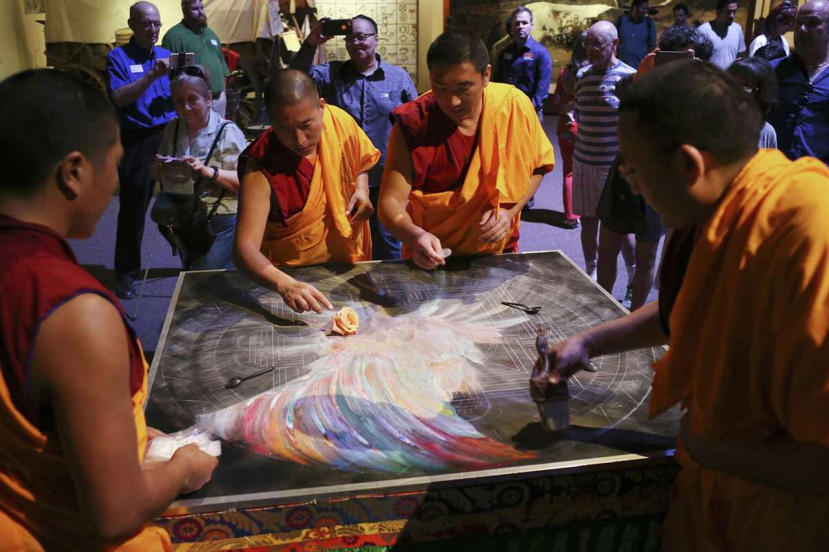 Buddhist monks from the Drepung Loseling Monastery gather the sand from a mandala painting during a Closing Ceremony at the Institute of Texan Cultures, Sunday, Oct. 1, 2017. The monks started creating the sand painting on Thursday and ended with the dispersing of the sand into the San Antonio River Sunday afternoon.
