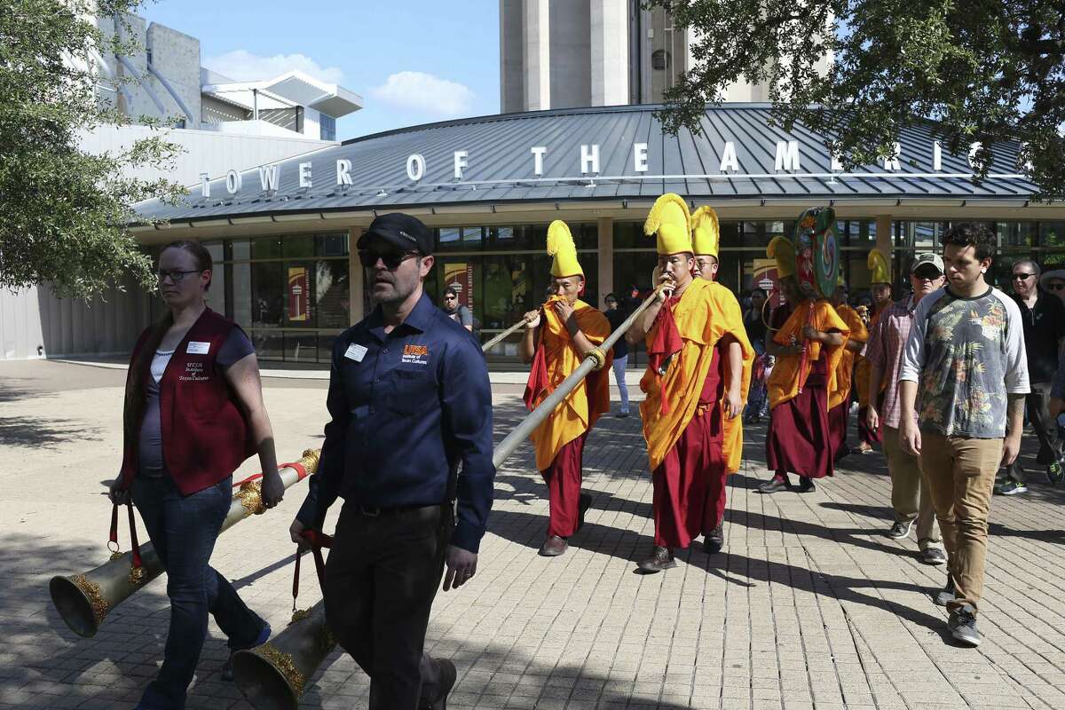 People join Buddhist monks from the Drepung Loseling Monastery in a sand mandala painting Closing Ceremony procession by the Tower of the Americas, Sunday, Oct. 1, 2017. The monks started creating the mandala sand painting on Thursday at the Institute of Texan Cultures and ended with the dispersing of the sand into the San Antonio River Sunday afternoon.