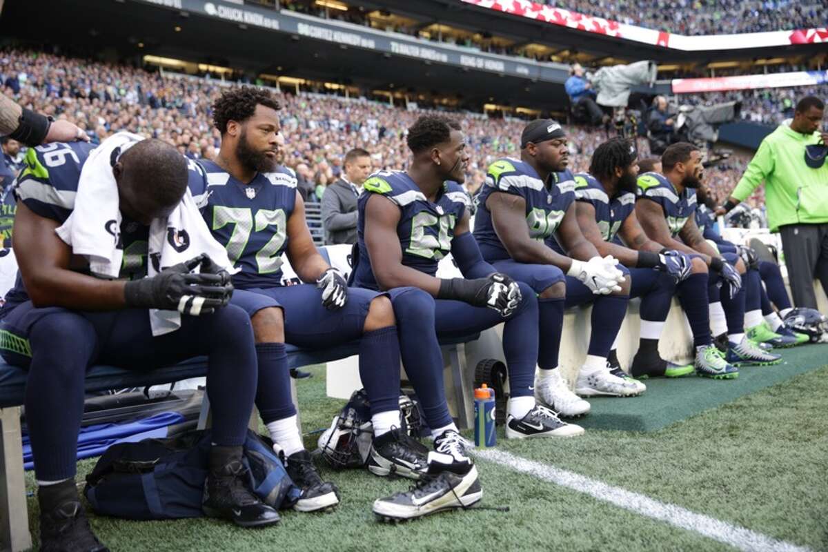 Seahawks players sit during the playing of the national anthem before Seattle's game versus the Indianapolis Colts at CenturyLink Field on Sunday, Oct. 1, 2017.