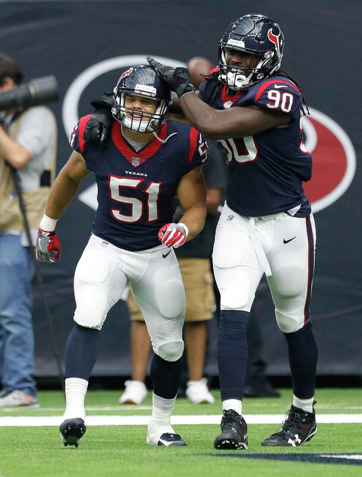 The Texans' Dylan Cole (51) celebrates his fourth-quarter touchdown off a 25-yard interception return with fellow linebacker Jadeveon Clowney.