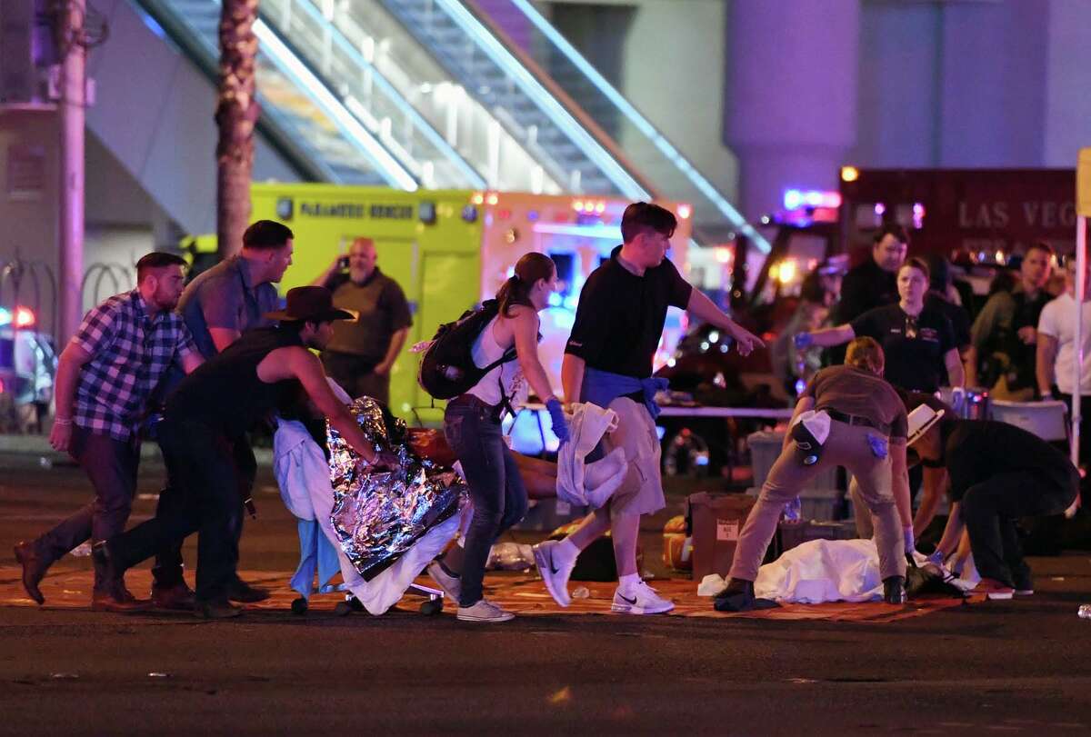An injured person is tended to in the intersection of Tropicana Ave. and Las Vegas Boulevard after a mass shooting at a country music festival nearby on October 2, 2017 in Las Vegas, Nevada. A gunman has opened fire on a music festival in Las Vegas, killing over 20 people. Police have confirmed that one suspect has been shot dead. The investigation is ongoing. (Photo by Ethan Miller/Getty Images)